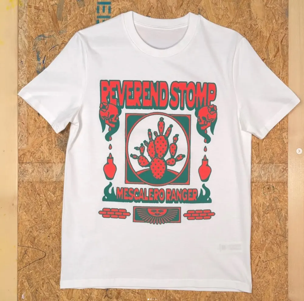 Weißes T-Shirt mit rot-grünem Mescalero-Ranger-Motiv auf einer OSB-Platte